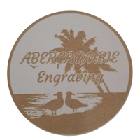 Round coaster with palm tree and seagull design, featuring 'Abercrombie Engraving' text.