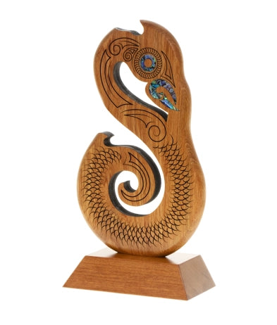 Wooden Manaia award with intricate designs and inlayed Pāua shell
